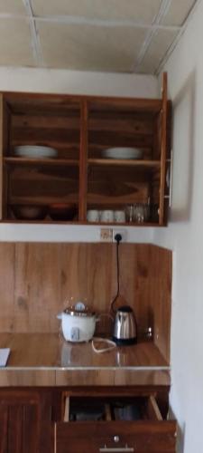 a kitchen with wooden cabinets and a bowl on a counter at Stay Calm in Anuradhapura