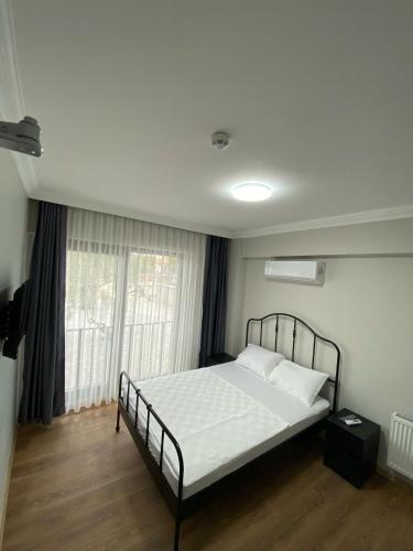a bedroom with a bed with white sheets and a window at ROSe OTEL in Ezine