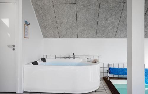 a bathroom with a large white tub in a room at Awesome Home In Rudkøbing With Sauna in Spodsbjerg