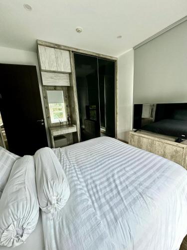 a bedroom with a large white bed and a window at 2BR Peaceful & Cozy Family Condo in Jakarta