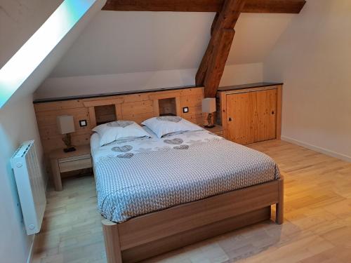 une chambre avec un grand lit dans un grenier dans l'établissement La perle Bressaude avec balcon et magnifique vue, à La Bresse