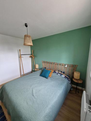 - une chambre dotée d'un lit avec un mur vert dans l'établissement Maison Saint Pierre Oleron, à Saint-Pierre-dʼOléron