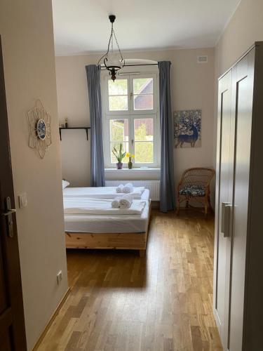 a bedroom with a bed and a window at Leśniczówka Szeroki Bór in Szeroki Bór