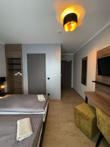a bedroom with two beds and a flat screen tv at Pension Meeresluft in Rostock