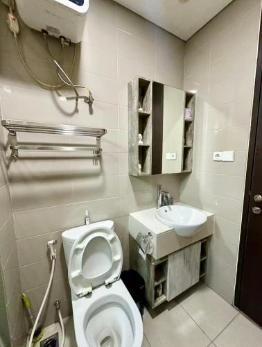 a bathroom with a toilet and a sink at 2BR Peaceful & Cozy Family Condo in Jakarta