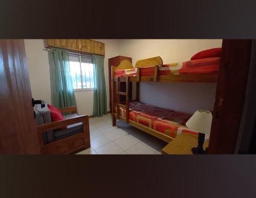 a bedroom with two bunk beds and a window at La casa de Yoni in Las Toninas