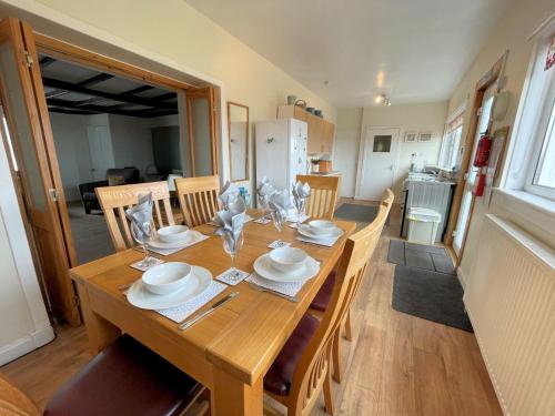 a wooden table with chairs and a dining room at Traditional Cottage with Beautiful Views - Pass the Keys in Isle of Whithorn