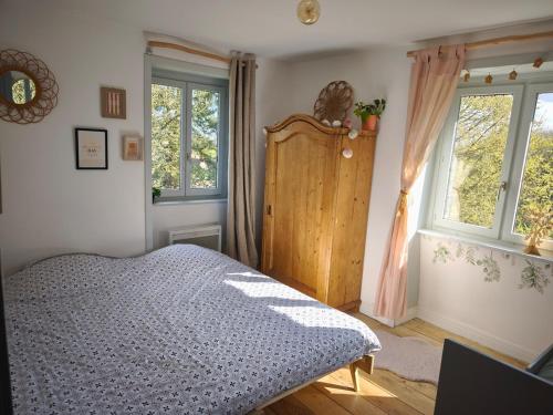 une chambre avec un lit et deux fenêtres dans l'établissement Cassandra's Cottage, à Sebourg