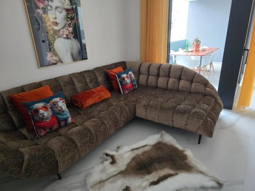 a brown couch sitting in a living room with pillows at Miliva Apartments in Vir