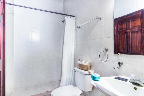 a bathroom with a toilet and a sink and a shower at Tropical Sunset at Sunset Villas in West End in Roatan