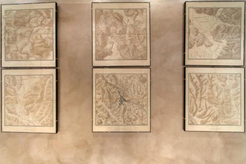 a wall with four framed pictures on a wall at La Martinella by Palazzo Bianchini in Siena