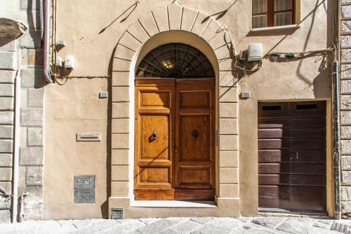 a wooden door in an archway on a building at La Martinella by Palazzo Bianchini in Siena