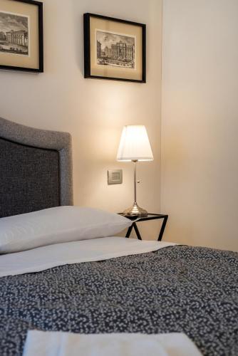 a bedroom with a bed and a lamp on a table at La Martinella by Palazzo Bianchini in Siena