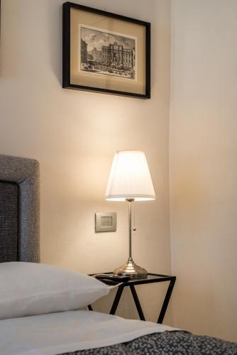a lamp sitting on a table next to a bed at La Martinella by Palazzo Bianchini in Siena