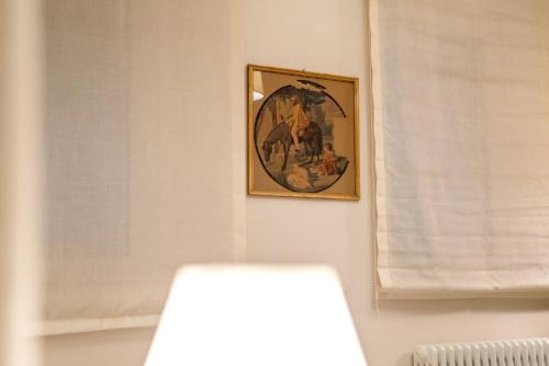 a picture hanging on a wall in a room at La Martinella by Palazzo Bianchini in Siena