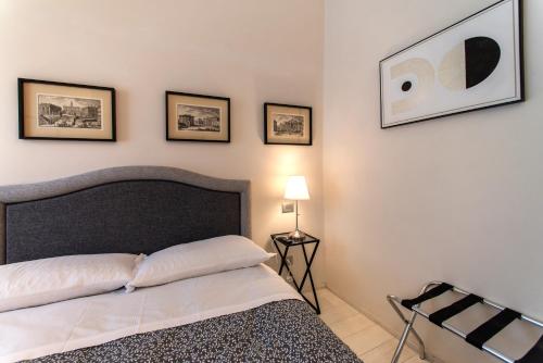 a bedroom with a bed and four pictures on the wall at La Martinella by Palazzo Bianchini in Siena