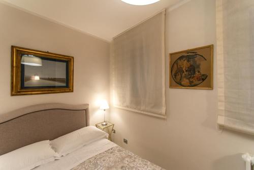 a bedroom with a bed and a picture on the wall at La Martinella by Palazzo Bianchini in Siena