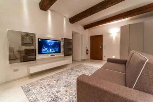 a living room with a couch and a flat screen tv at La Martinella by Palazzo Bianchini in Siena