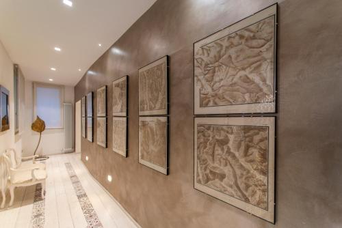 a hallway with a bunch of paintings on the wall at La Martinella by Palazzo Bianchini in Siena