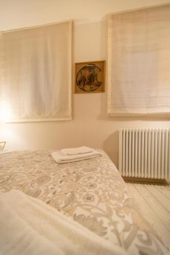 a bed in a bedroom with a window and a radiator at La Martinella by Palazzo Bianchini in Siena
