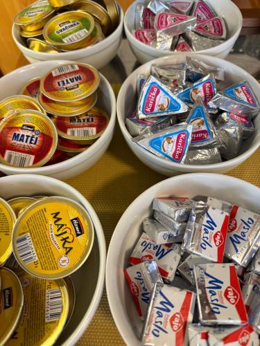 a table topped with white bowls filled with candy bars at Penzión Bojnice in Bojnice