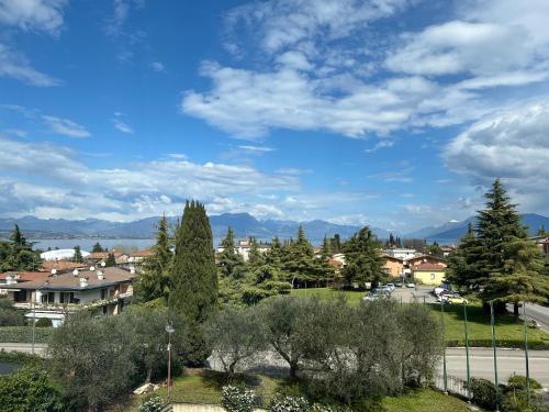 a view of a town with trees and mountains at Hotel Villa Maria in Desenzano del Garda