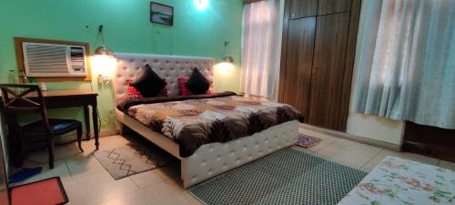 a bedroom with a bed and a desk and a computer at UVs Homestay in Haridwār
