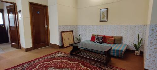 a living room with a couch and a rug at UVs Homestay in Haridwār