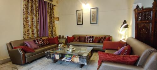 a living room with couches and a coffee table at UVs Homestay in Haridwār