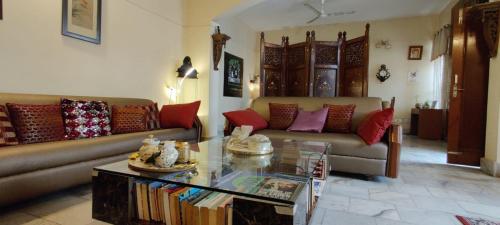 a living room with two couches and a coffee table at UVs Homestay in Haridwār