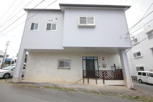 a white house with two columns at Himawari Villa in Okinawa City