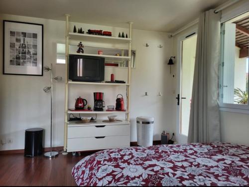 a bedroom with a bed and a tv on a shelf at chambre privée Gournay sur Marne in Gournay-sur-Marne