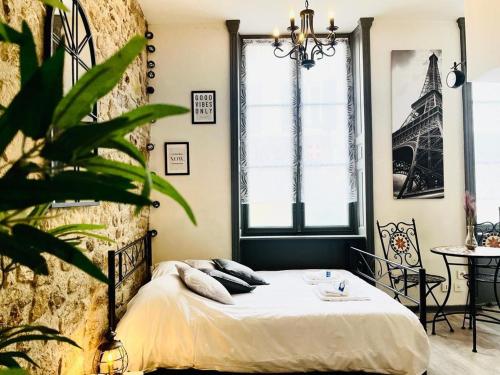 - une chambre avec un lit et un mur avec des fenêtres dans l'établissement capucin 2 super studio au pied de la cathédrale, à Reims