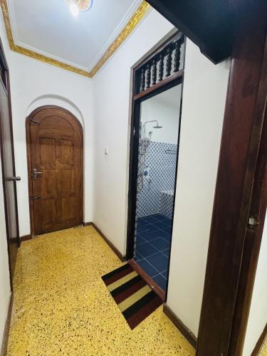 a hallway with a door and a mirror at Humming Birds Suites in Jaffna