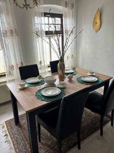 a dining room table with chairs and a vase on it at Le petit Charme - Wohnen in einer historischen Villa in Suhl