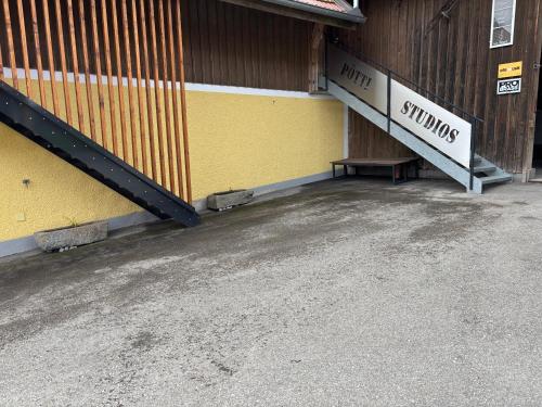 a yellow building with a sign on the side of it at Pötti Studios in Zupfing