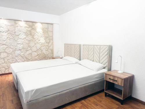 a bedroom with a large white bed and a night stand at Zunfthaus zu Wirthen in Solothurn