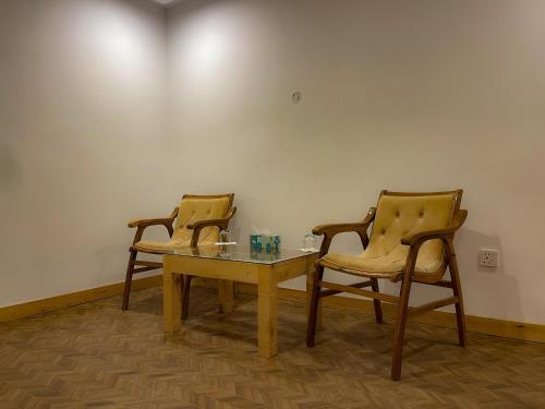 two chairs and a table in a room at Kesar Palace Hotel & Restaurant, Skardu in Skardu