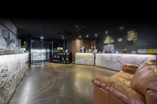 a bar with a couch in the middle of a room at Hotel ON in Uiwang