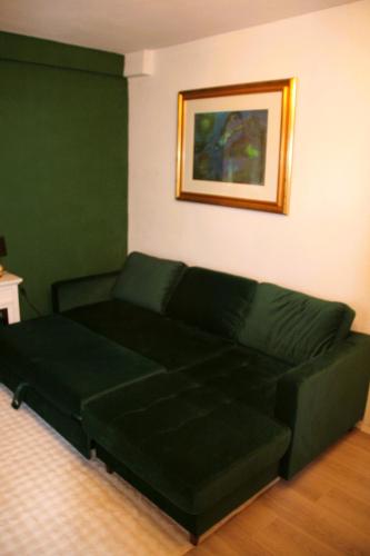 a green couch in a living room with a painting at Le petit Charme - Wohnen in einer historischen Villa in Suhl
