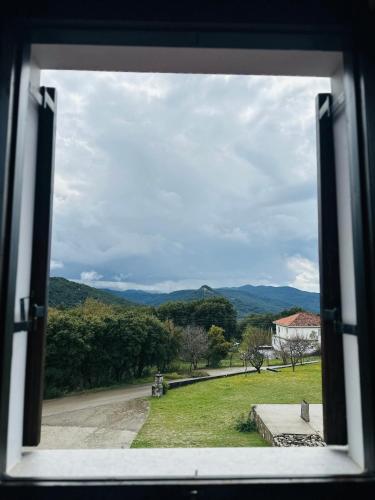 a view from a window of a field and a road at Panthoron Tzoumerka in Vourgareli
