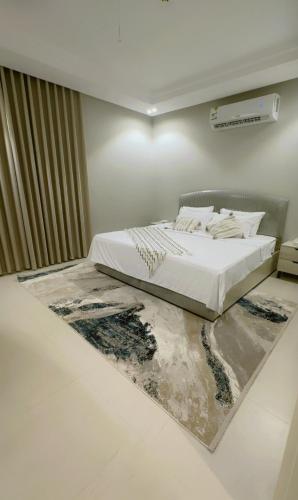 a bedroom with a bed with a rug on the floor at Dar Al Mashaer Luxury Apartment #112 in Mecca