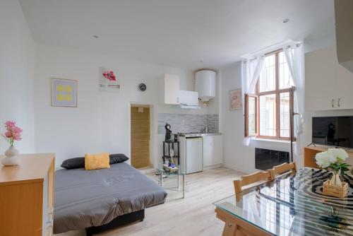 un salon avec un lit et une table en verre dans l'établissement Studio 5, à Villeurbanne