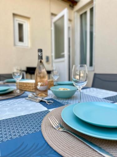 une table avec des assiettes bleues et des verres à vin dessus dans l'établissement Maison Cosy à Vichy, à Vichy