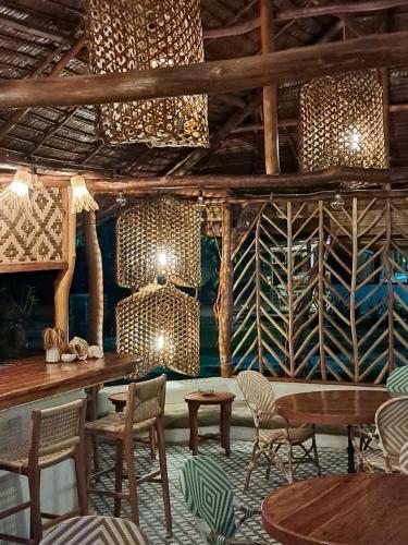 a dining room with tables and chairs and chandeliers at Villa Tua, Beach Pool & Spa in Letman