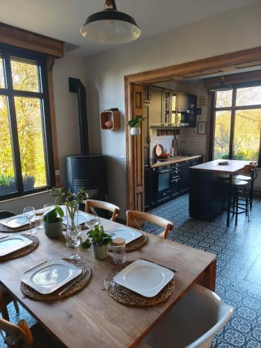 - une table en bois avec des assiettes dans la cuisine dans l'établissement Le cottage de Cassandre, à Sebourg