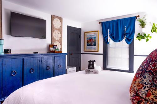 a bedroom with a large bed with a tv on the wall at Addison Choate in Rockport