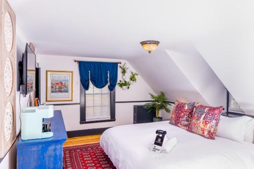 a bedroom with a white bed and blue curtains at Addison Choate in Rockport