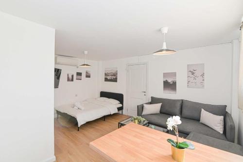 a living room with a couch and a bed at הדירה בלבן פלאי in H̱adera