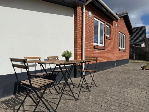 a table and chairs with a potted plant on a patio at GoodVibe House Billund by KIRIJA in Billund